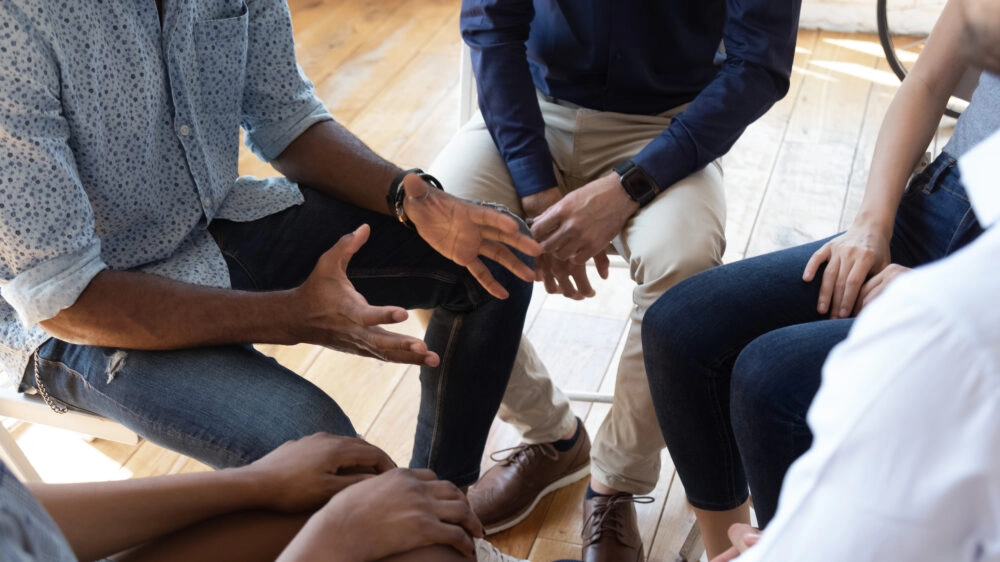 Group of people seated in a tight circle
