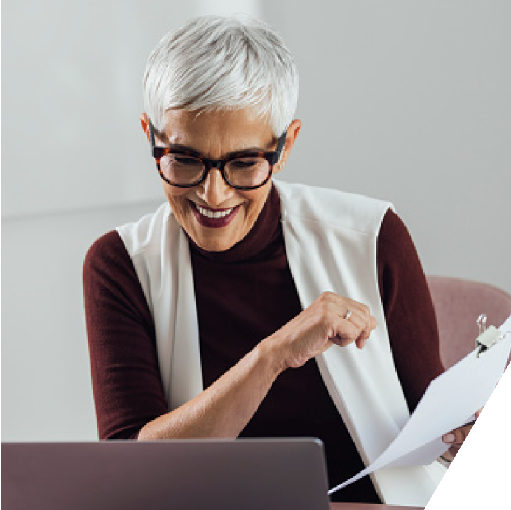 Woman on a laptop holding papers