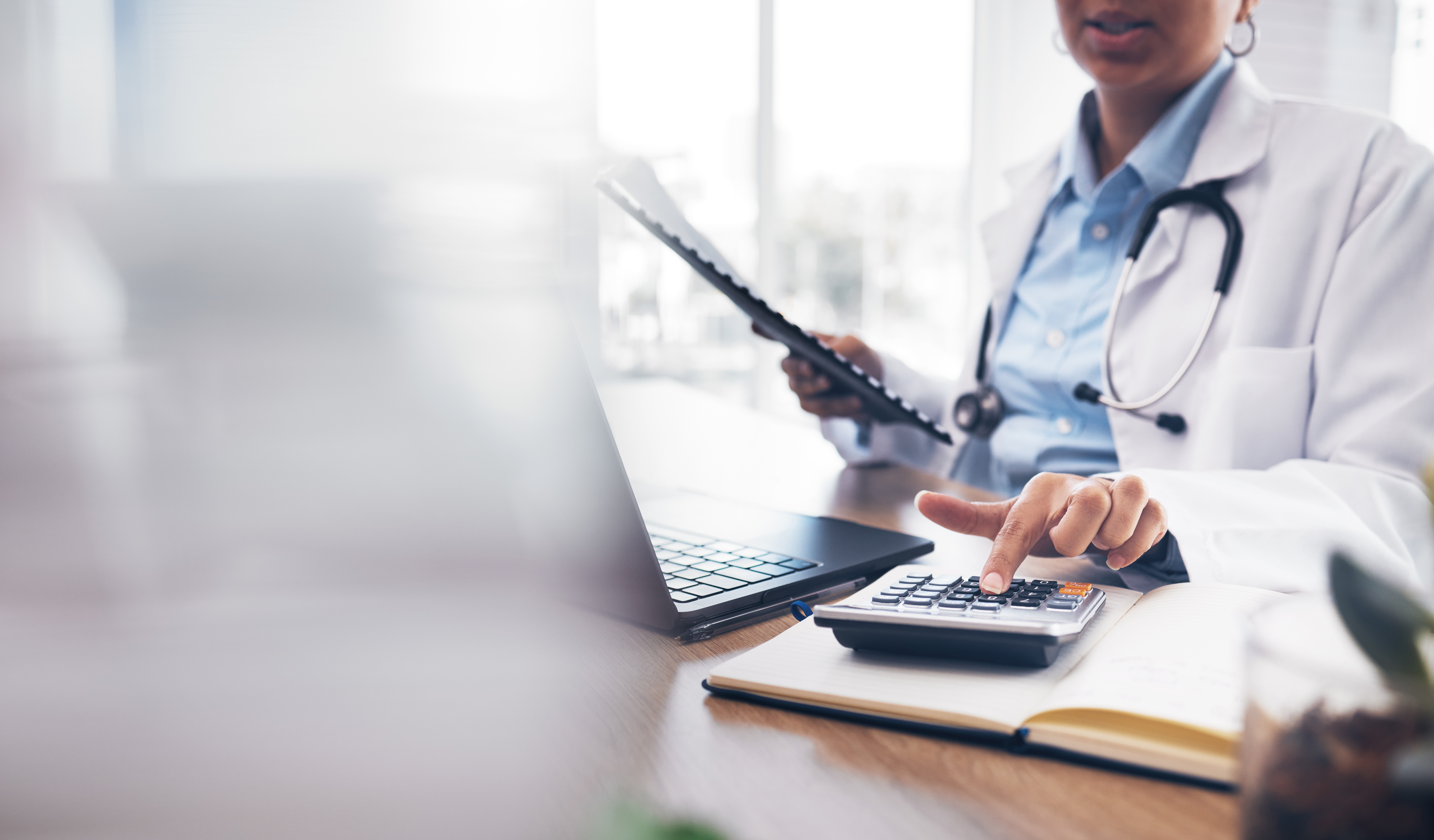Doctor at a desk using a calculator