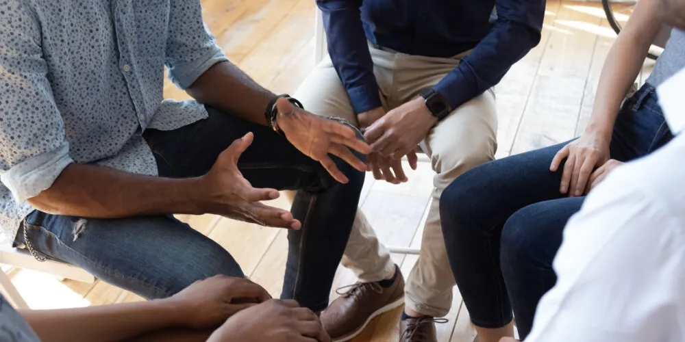 Group of people seated in a tight circle